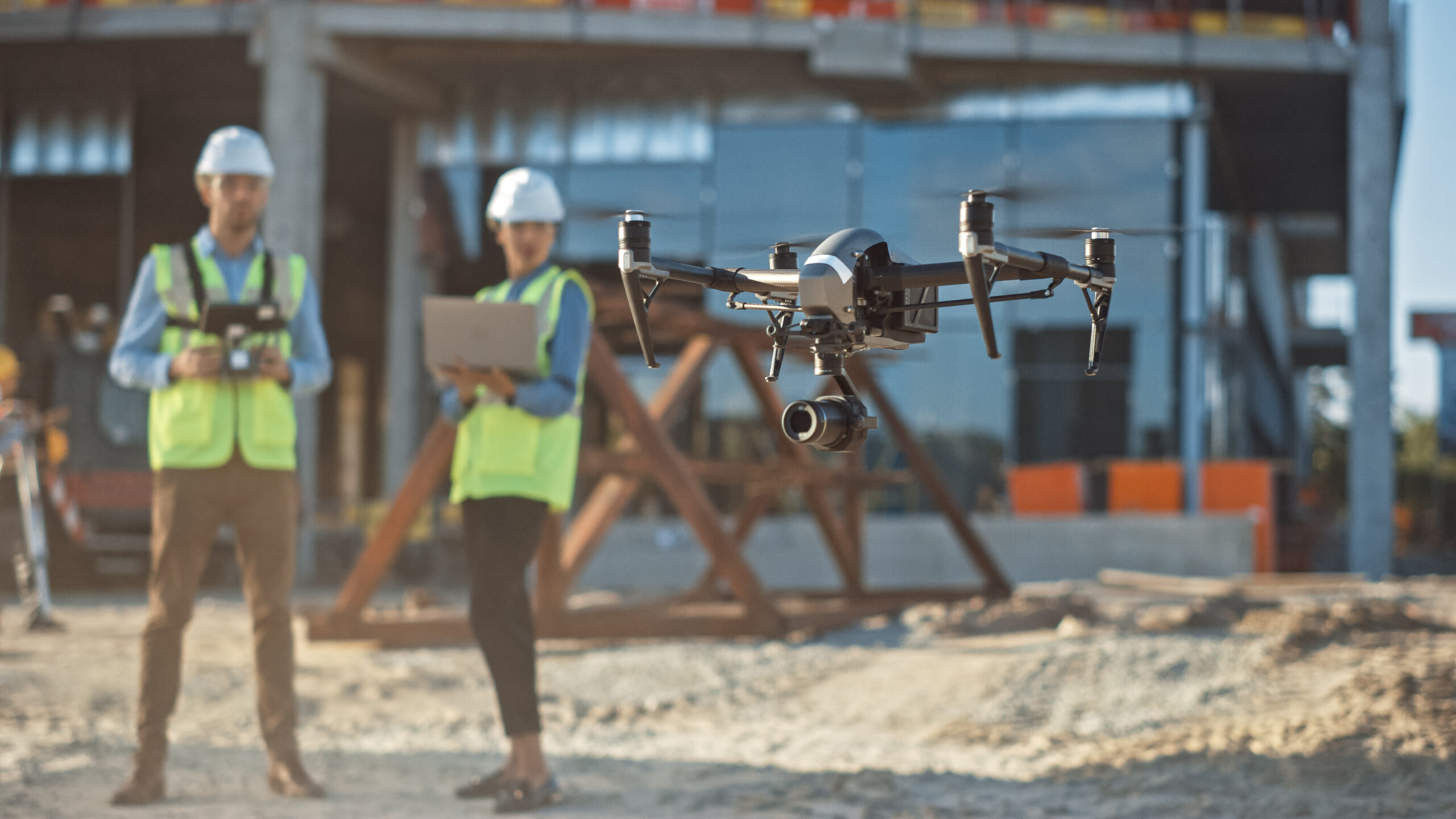 Diverse Team Of Specialists Pilot Drone On Construction Site. Ar